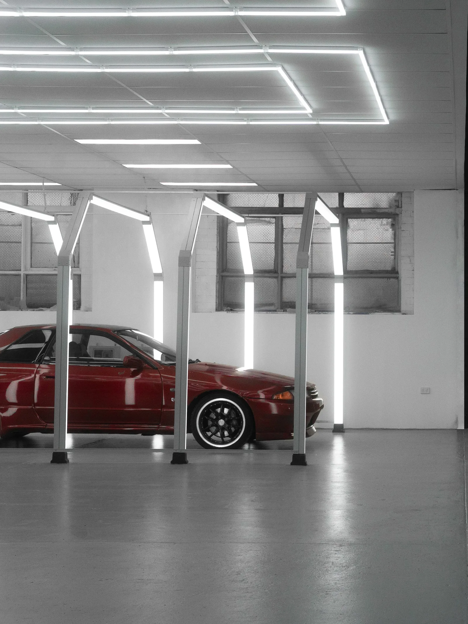 A red Nissan Skyline in the illuminated Sunshine Accident Repair Centre workshop